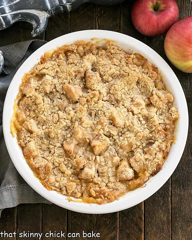 Overhead view of apple crumble in a white ceramic pie plate.