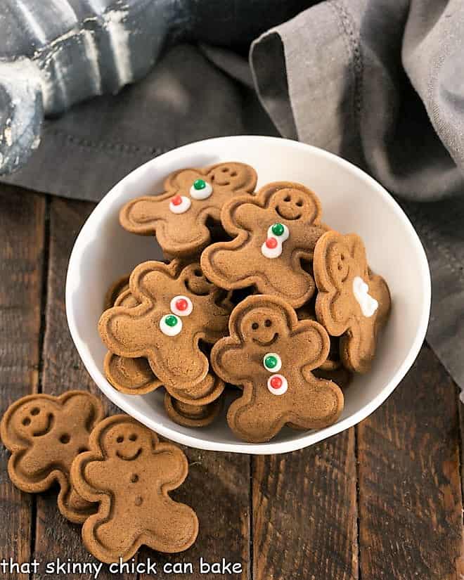 Mini gingerbread men cookies in a small white bowl.