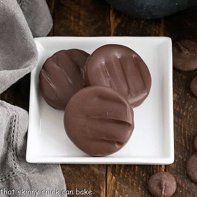 Overhead view of 3 peppermint patties on a square white plate