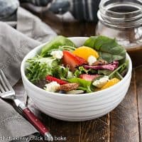 Spinach Strawberry Salad in a white bowl with a red handled fork