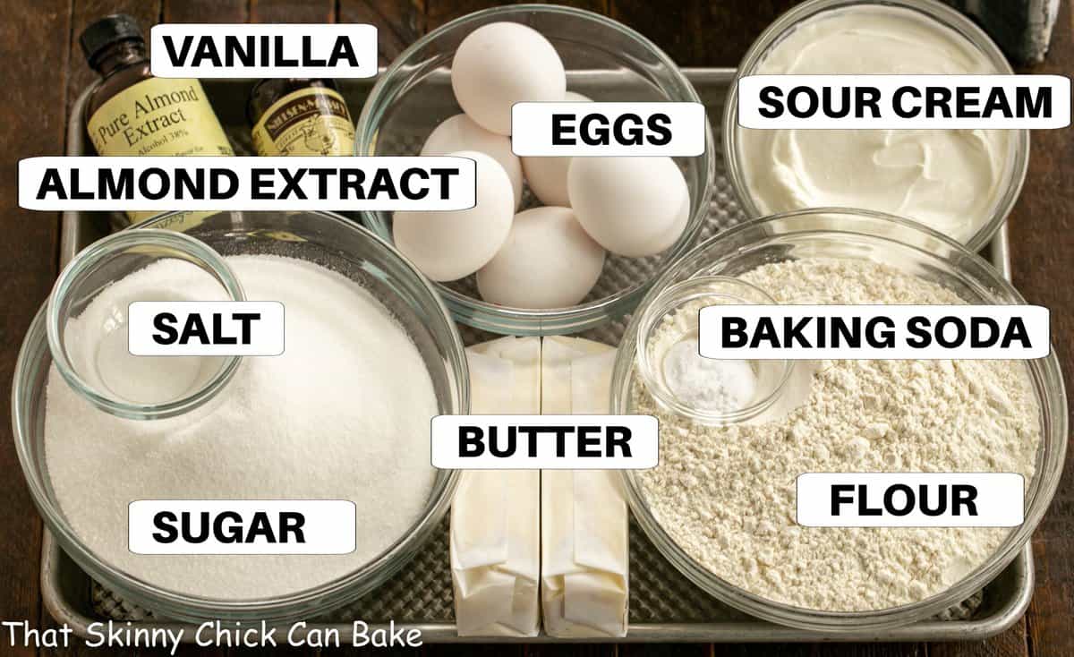 Ingredients for sour cream pound cake on a sheet pan with labels.