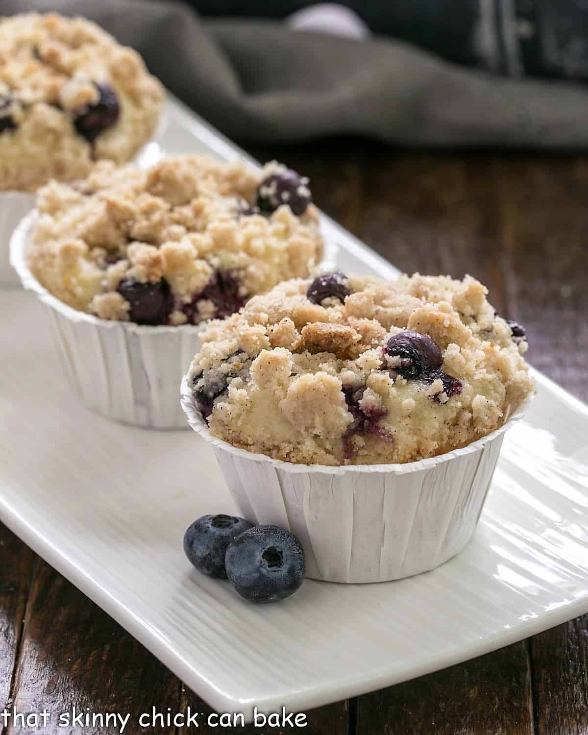 Blueberry Cream Cheese Muffins on a white ceramic tray.