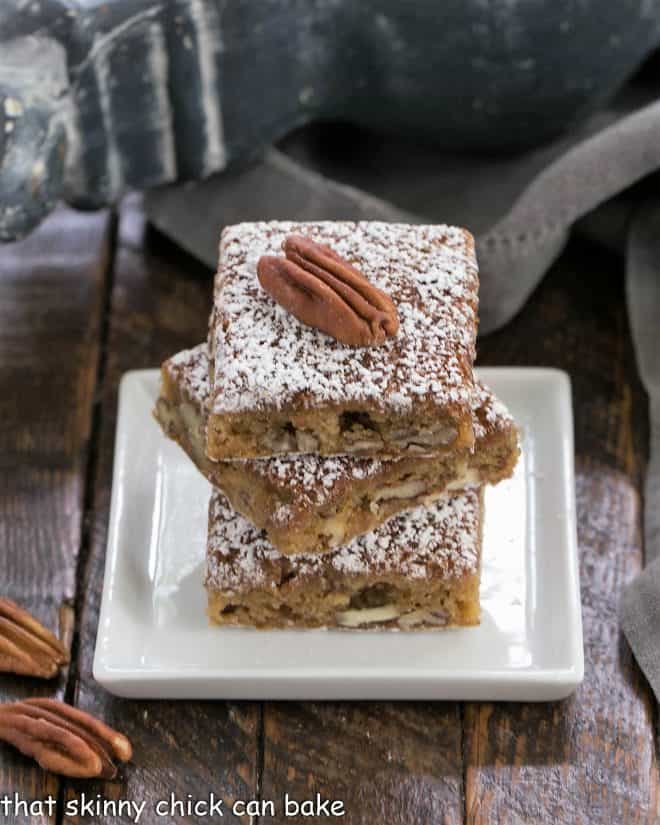 3 pecan bars stacked on a square white plate
