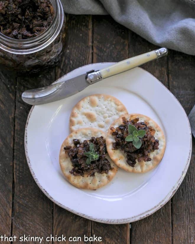 Overhead view of bacon jam on crackers witha ivory handle knife