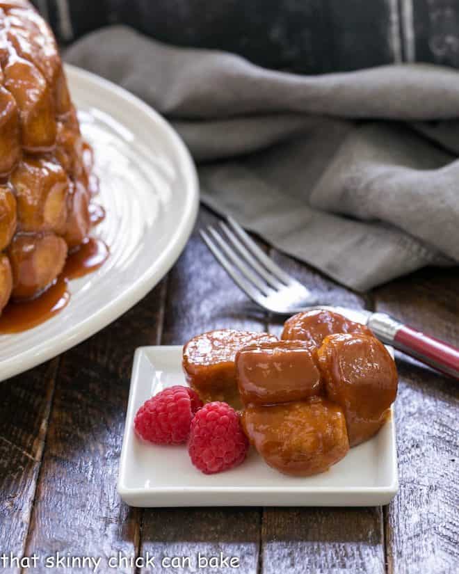 Bubble bread on a square white plate with 2 plump raspberries