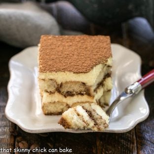 Slice of the best tiramisu recipe with a bite on the tines of a fork
