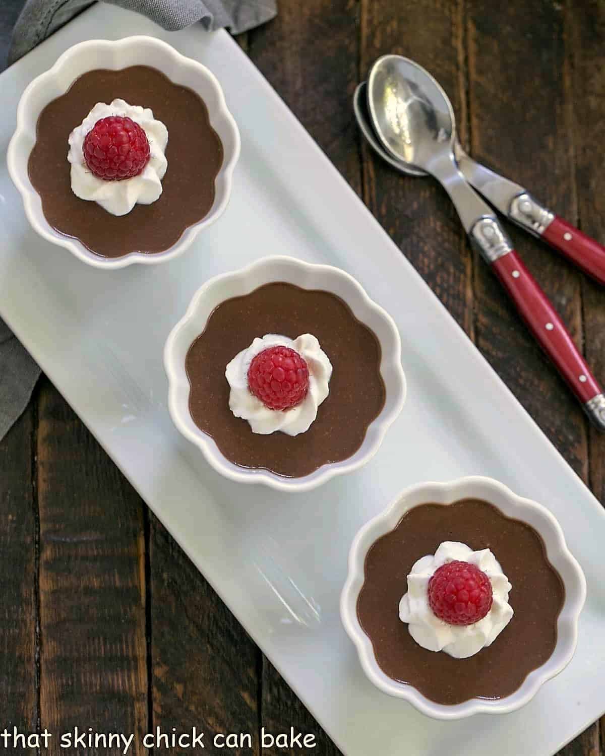 3 ramekins with Italian chocolate pudding on a white ceramic tray.