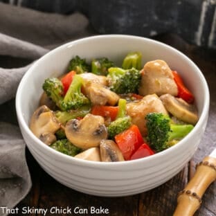 Chicken Broccoli Stir Fry in a white bowl and a bamboo handled fork.