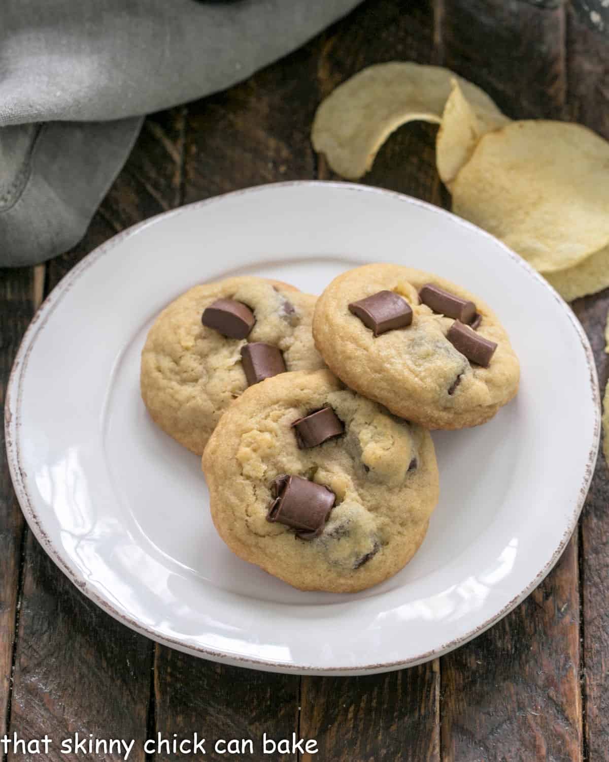 Overhead view of 3 potato chip cookies on a white dessert plate.