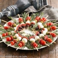 Appetizer skewers arranged in a weath pattern on a serving plate