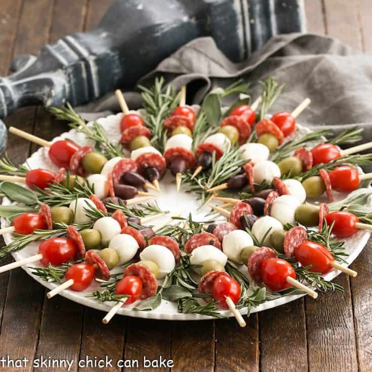 Appetizer skewers arranged in a weath pattern on a serving plate