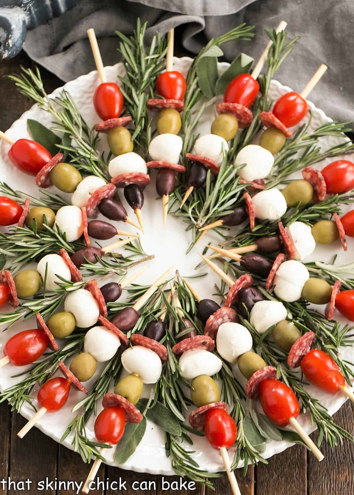 Overhead view of kabob appetizers on a white plate.