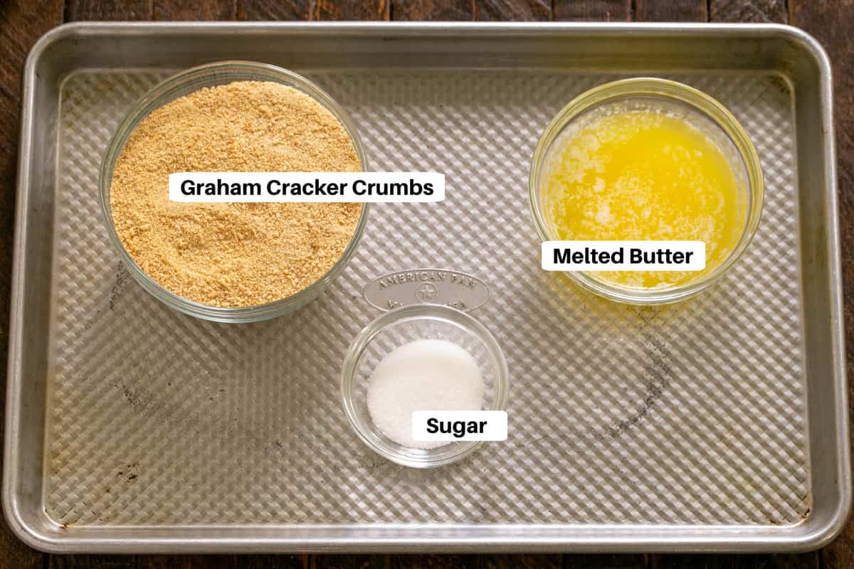 Graham cracker crust ingredients with labels on a sheet pan.