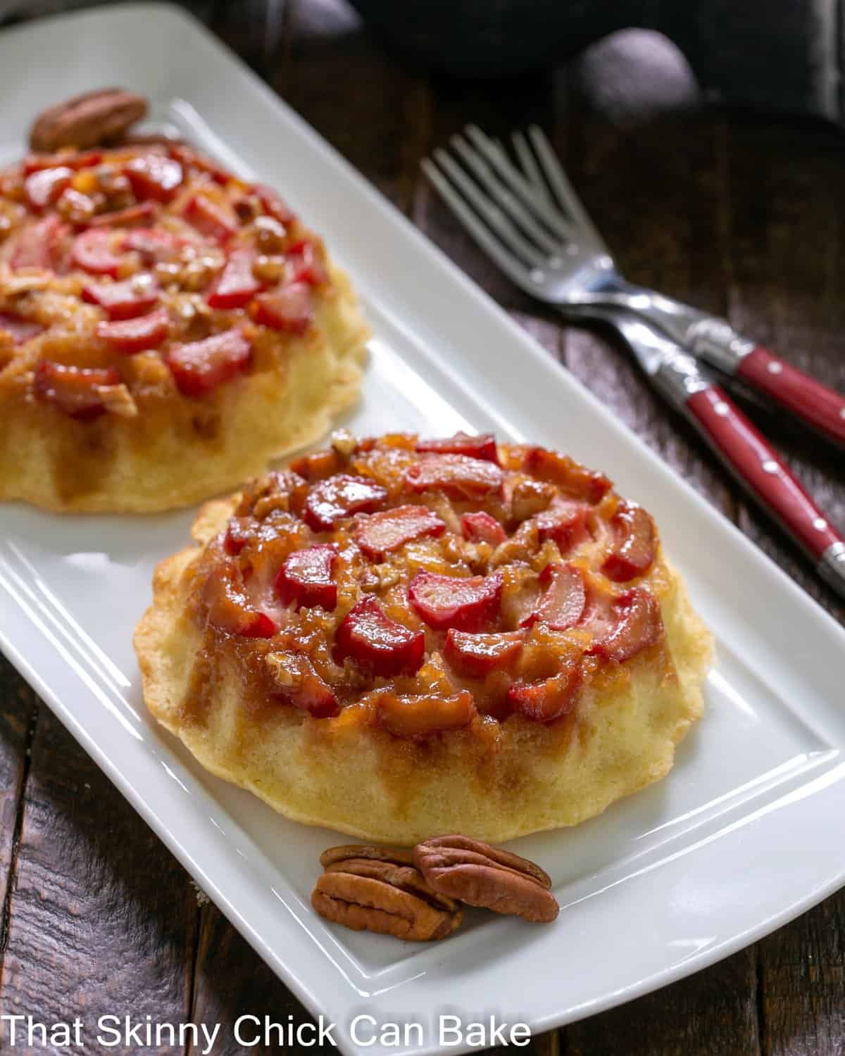 Fresh Rhubarb Upside-down Baby Cakes on a white ceramic tray.