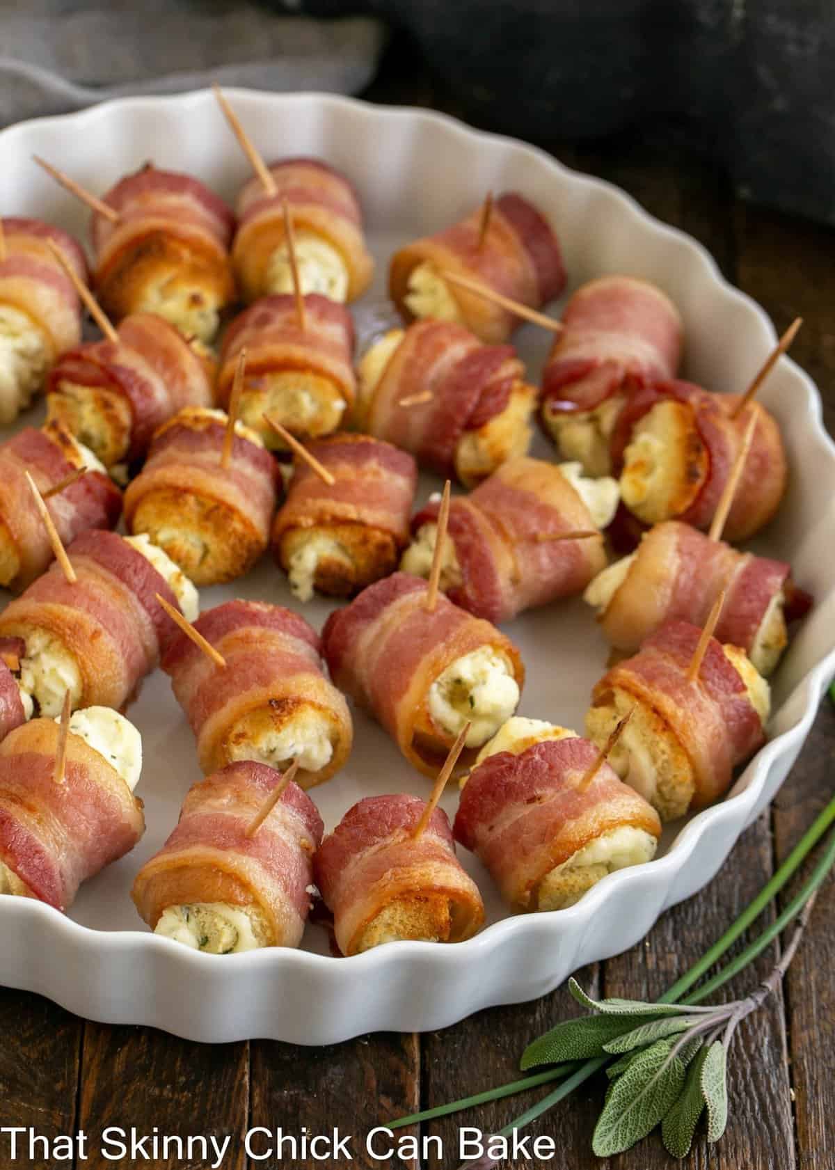 Overhead view of bacon and cheese rolls in a rimmed, white serving dish.