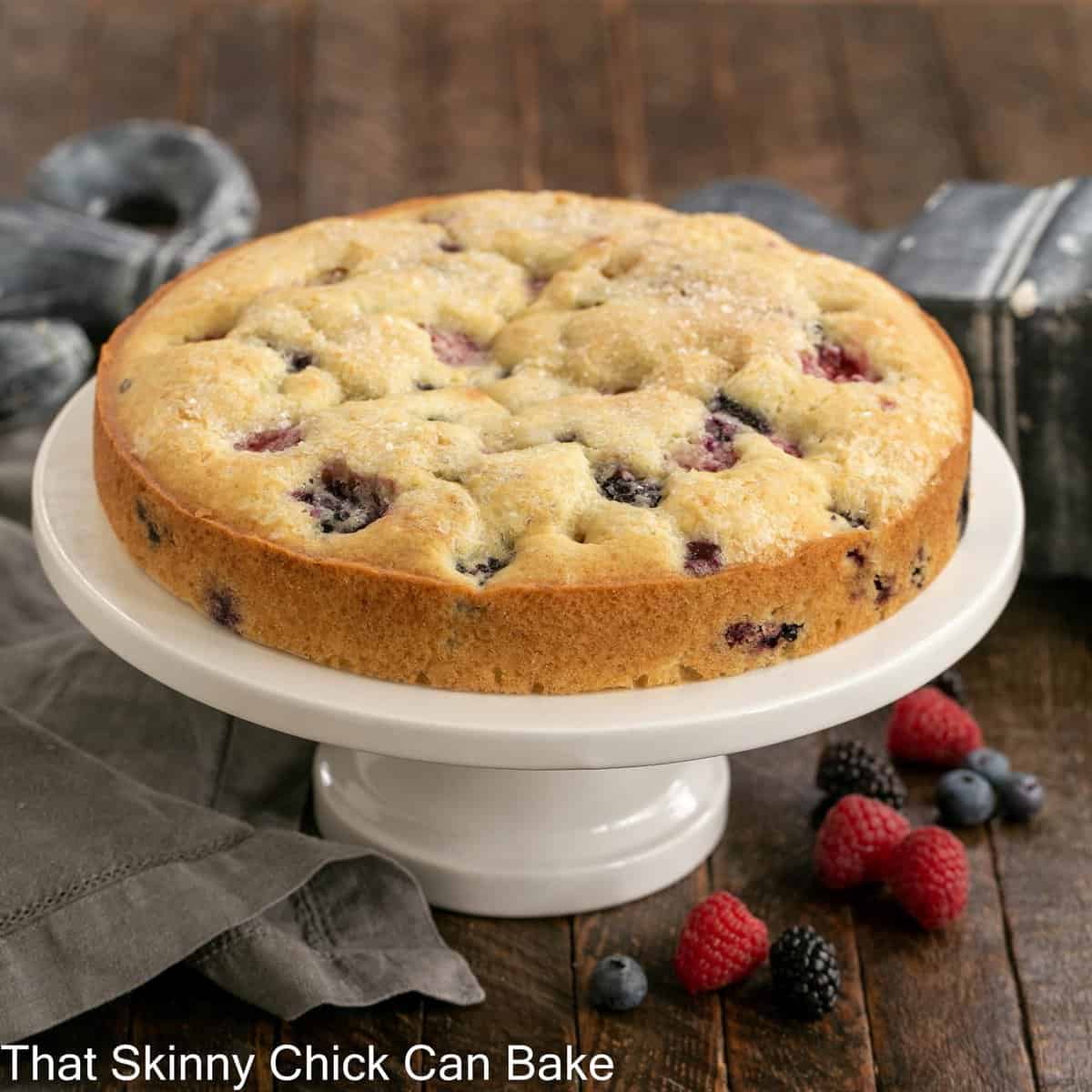 One layer cake with berries on a cake stand.