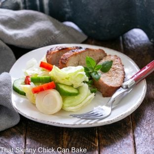 Tenderloin slices on a white plate with salad