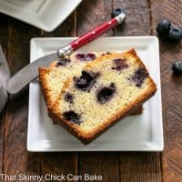 Blueberry Poppy Seed Bread slices on a square white plate with a red handled knife.