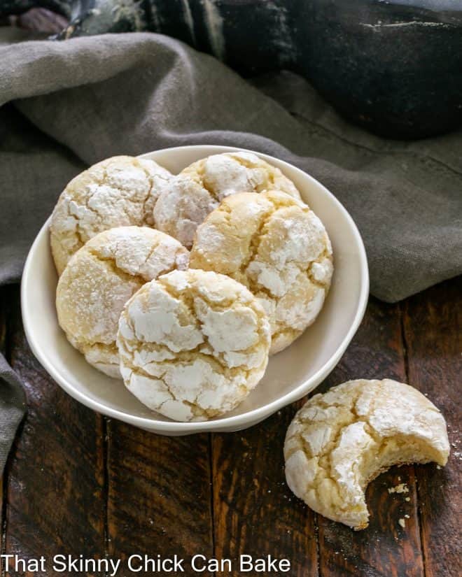 Overhead view of a small bowl of 5 cookies and one to the side with a bite removed.