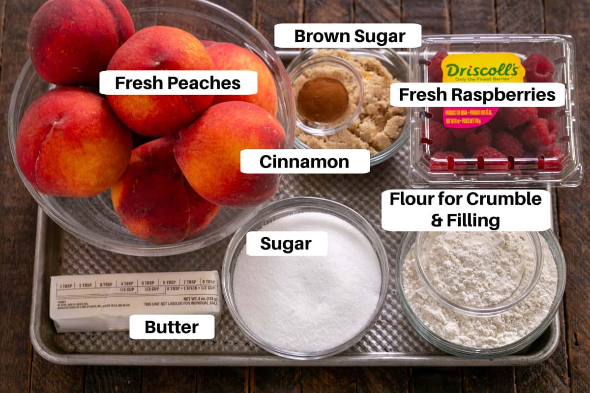 Peach Raspberry Crisp ingredients on a sheet pan with labels.