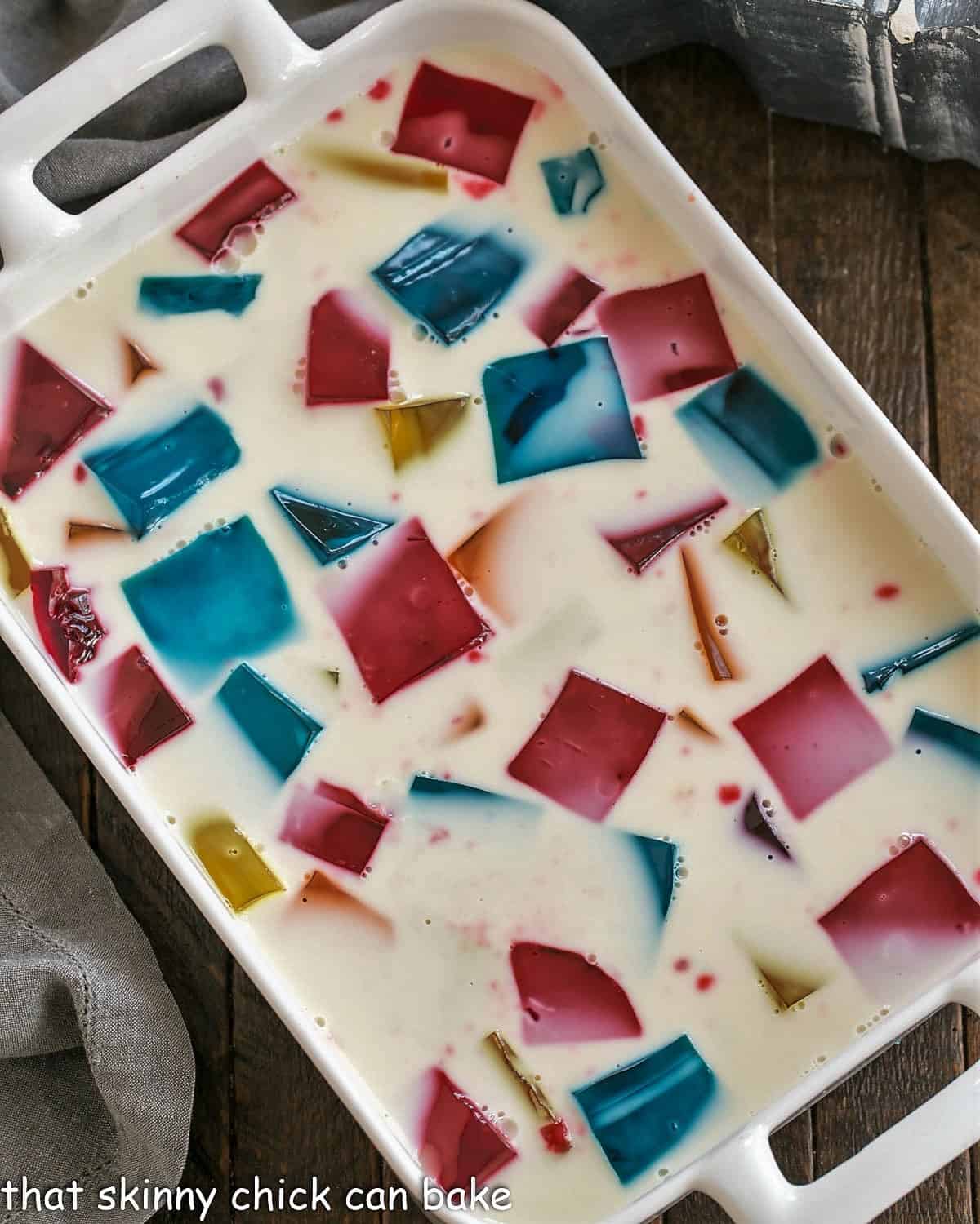 Overview of stained glass jello in a white casserole dish.