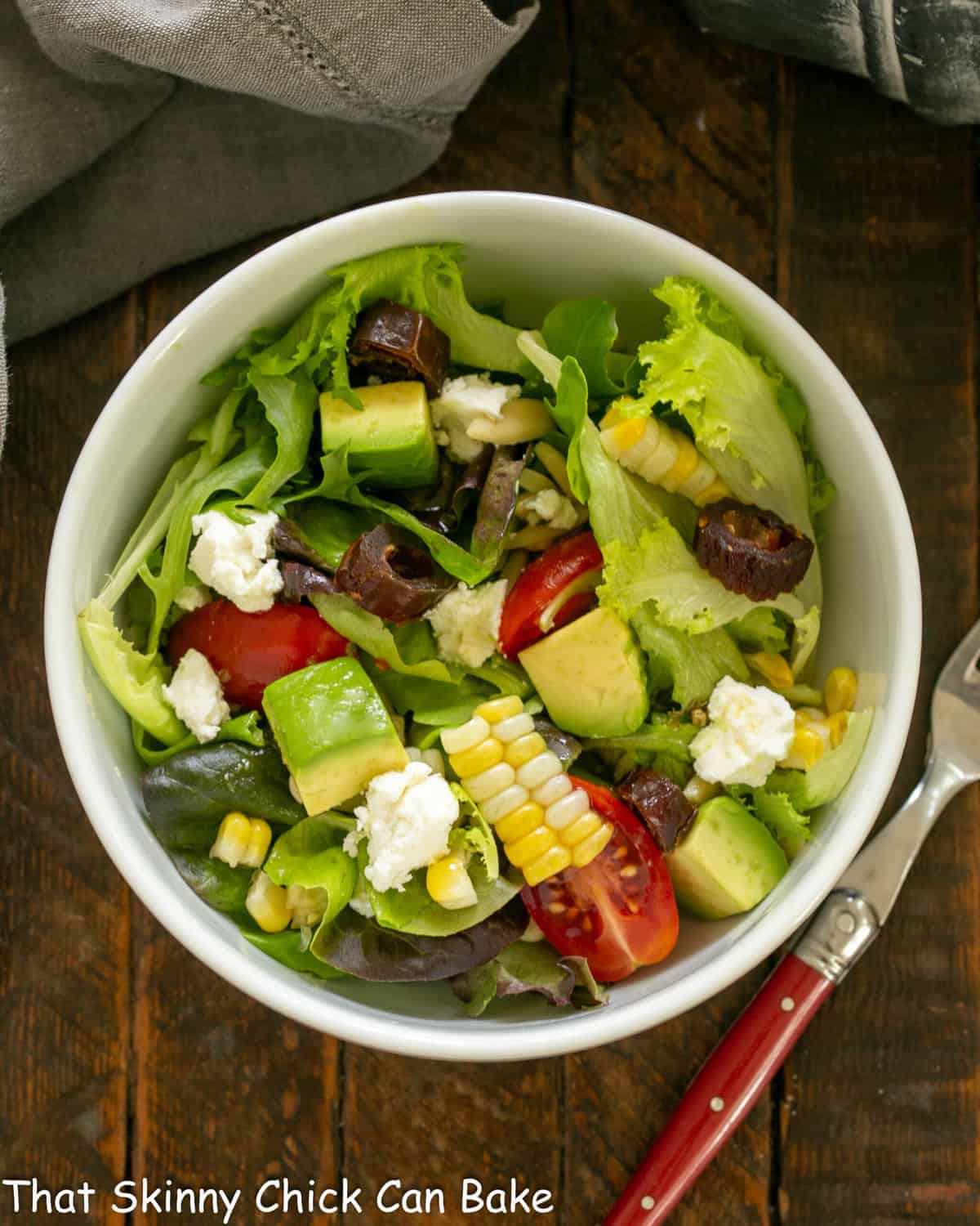 Overhead view of a small macho salad with a red handled fork.