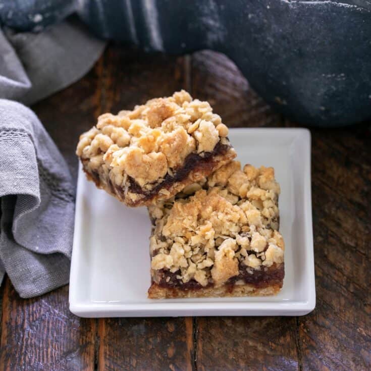 2 date streusel bars on a small square white plate.