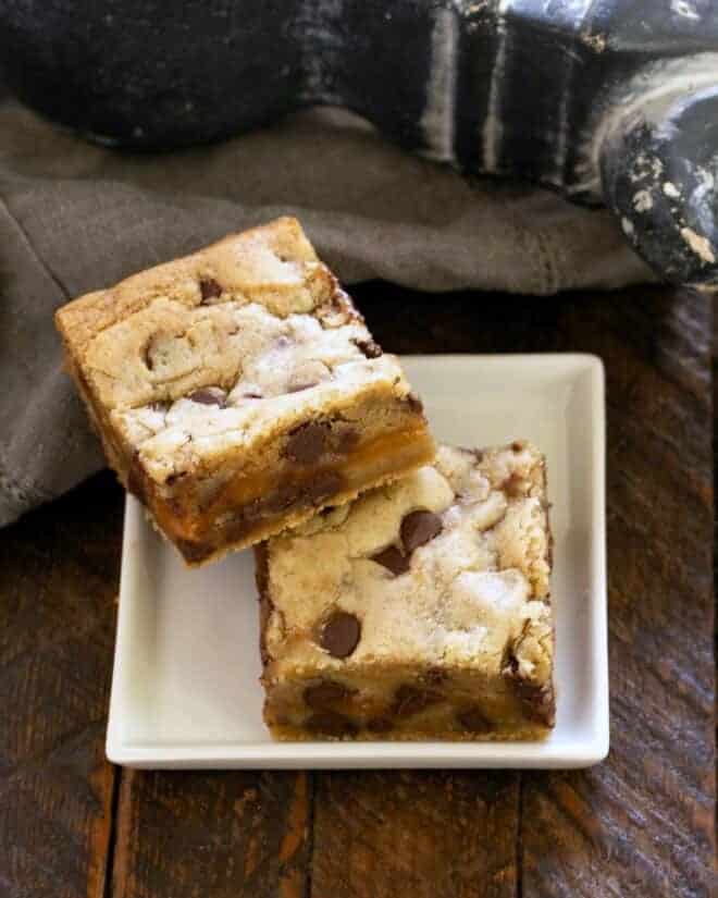 2 chocolate caramel bars on a square white plate.