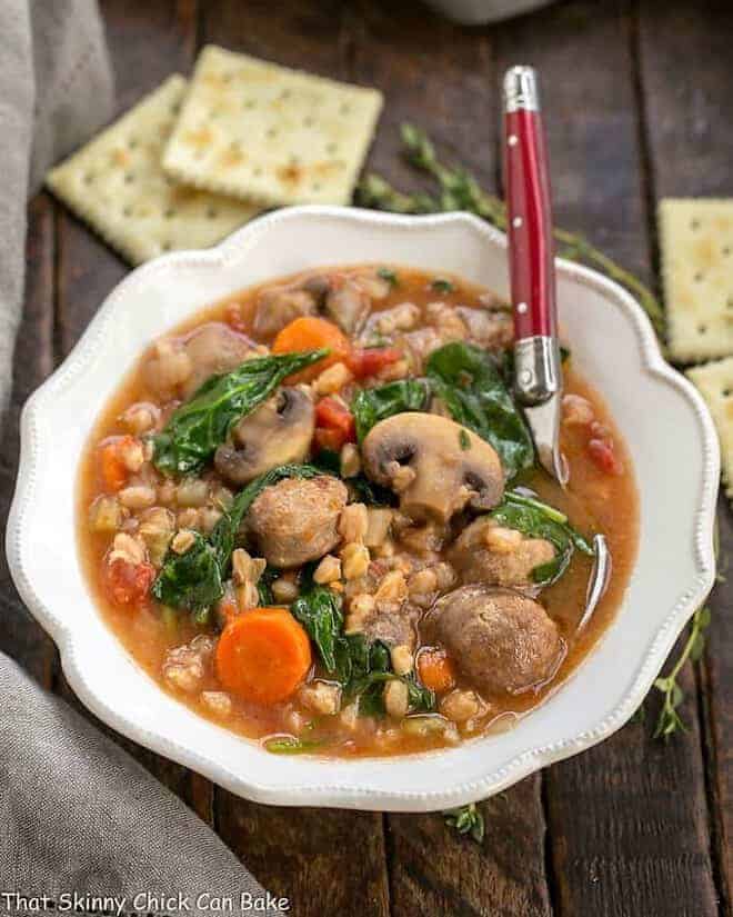 Rustic Farro Soup in a scalloped soup bowl with a spoon.