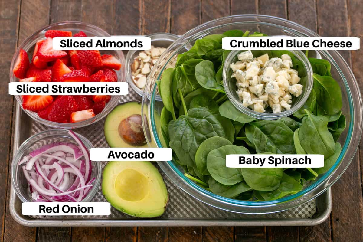 Spinach Salad with Strawberries and Blue Cheese ingredients with labels on a sheet pan.