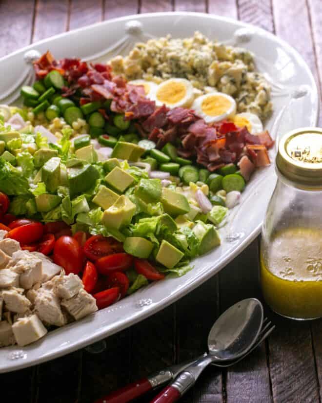 Cobb Salad arranged on serving platter with dressing nearby.