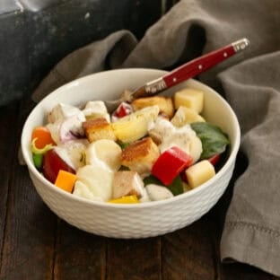 Salad Bar at home salad in a white bowl with a red handled fork.