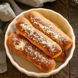 Overhead view of homemade breadsicks in a white bowl.